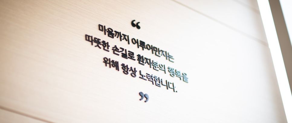 골든시니어치과 진료실 벽에 새겨진 문구: 마음까지 어루만지는 따뜻한 손길로 환자분의 행복을 위해 항상 노력합니다.